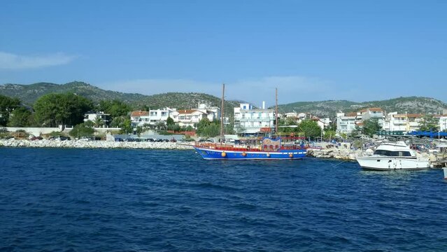 Small tourist village of Potos in the southern end of Thassos Island in Greece , Europe , with the specific architecture and blue Aegean Sea , seen from the pier , sunny summer day.