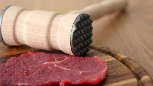 Dolly shot of Meat Tenderizer and Raw Steak.