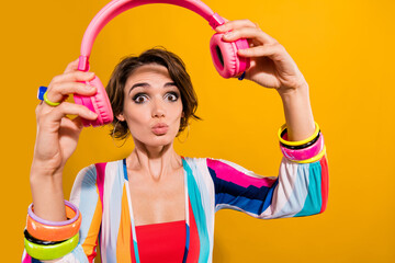 Photo of funky impressed lady wear striped costume putting on headphones send kiss isolated yellow...