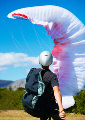 Man, parachute and launch sport with courage, healthy adventure and paragliding for extreme...