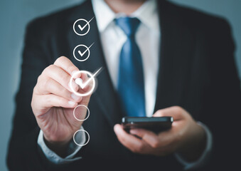 Businessman uses pen to mark correct mark in check box for quality document checklist and business approves business operations project concept.