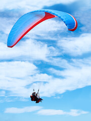 Man, parachute or paragliding in blue sky for adventure, flight freedom or courage with extreme sport. Pilot, nature and fearless in outdoor fitness for health, sports and wellness with glide in air