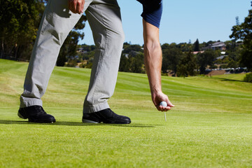 Obraz premium Sports, golf hole and person with ball on course playing game, practice and training for competition. Professional golfer, grass and hands of man placing tee for winning stroke, tournament or score