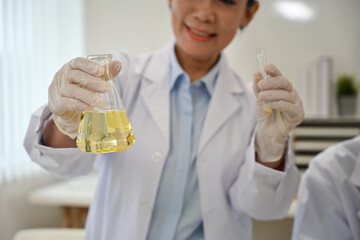 Close up image of Senior Laboratory worker woman mixes substances in a test tube