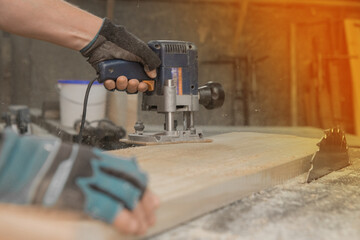 Hand male worker industry grinder tool object for woodworking board plank close-up sunlight glare