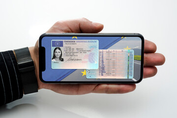 Digitaler Führerschein auf einem Handy in der Hand gehalten - obrazy, fototapety, plakaty