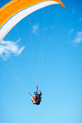 Man, paragliding and blue sky adventure fun in clouds for explore city, outdoor courage or fearless...