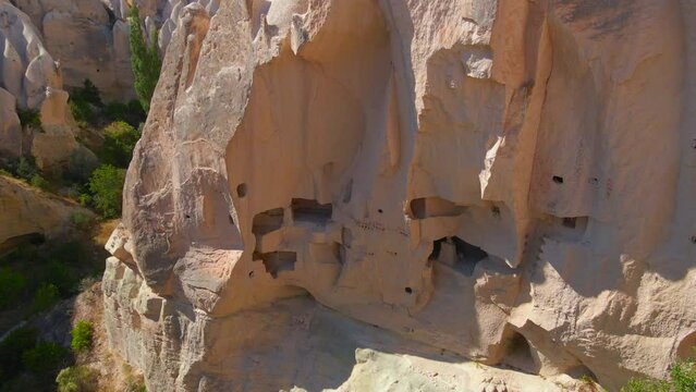 Embark on a visual journey with this mesmerizing aerial stock video capturing the essence of Cappadocia's cave dwellings near Goreme, Turkey. The bird's eye perspective unveils the unique charm of
