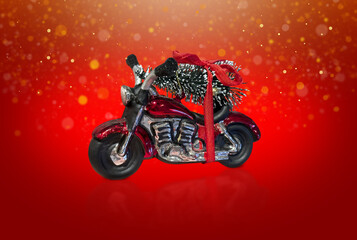 Glass Motorbike toy with Christmas tree on the top of it is on the red background