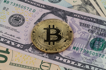 Golden bitcoin coin on a paper dollars money