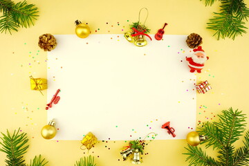 New Year composition frame on yellow background. Christmas white background with golden balls and fir branches. Top view, copy space, flat lay.	
