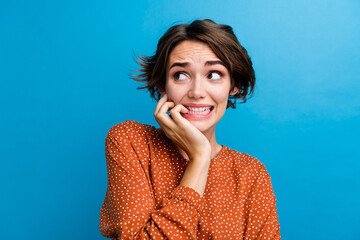 Photo portrait of pretty young girl bite nails look frightened empty space dressed stylish brown...