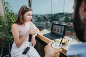 Young couple discusses new expansion, growth strategies, and opportunities for business development with freelancers and executives over coffee on a cloudy day in an urban cafe.