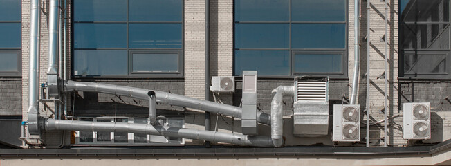 Air ventilation tube system and external air conditioners on the facade of a city building