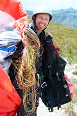 Paragliding, parachute or man in nature for portrait, happy or strings for training for flight preparation. Athlete, face or smile for fitness for outdoor wellness, helmet or equipment in countryside