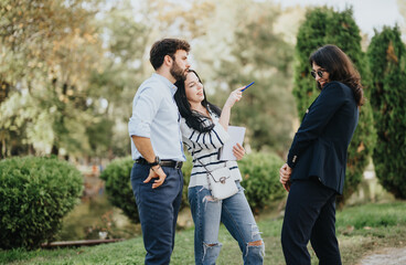 Fototapeta premium Students discussing and collaborating on a university project in a sunny park. They inspire each other to achieve their goals and prepare for exams successfully.