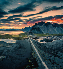 Vestrahorn mountain and road among black sand beach in the sunset at Stokksnes, Iceland