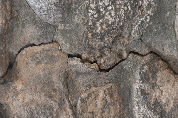 Crack on old stone wall or floor surface, broken texture, damaged background close-up