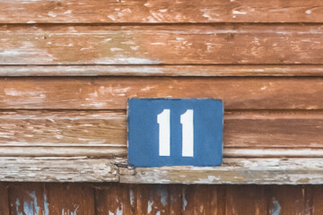 Symbol sign number 11 eleven house object close-up home macro soft focus on wooden background