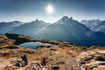 French Alps landscape of Lac des Cheserys with Mont Blanc massif and tourist climbing on sunny day...