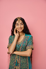 vertical shot of attractive jolly indian woman posing with her hand near face and looking away