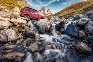Aiguilles d Arves with iconic mountain peak and vintage car crossing the waterfall in the valley at French alps, France