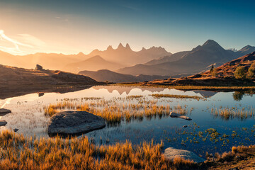 Sunrise shines over Lac Guichard with Arves massif and lake reflection in autumn at Aiguilles d...