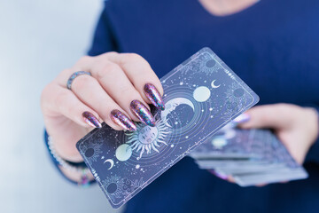 Female hands holding tarot cards for fortune telling and tricks