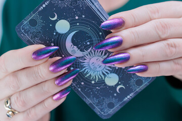 Female hands holding tarot cards for fortune telling and tricks