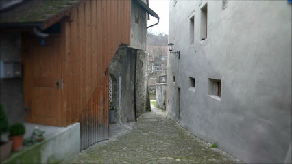 Fototapeta na wymiar Empty Narrow European ancient street in Switzerland. Traditional cobblestone and buildings