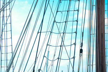 Tall ship rigging without sails. Blue sky background. 