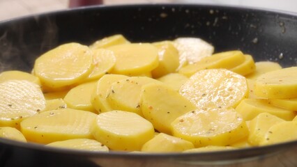 Pull out Shot Seasoned Potato Slices in a Pan.