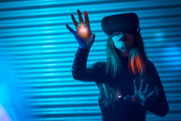 Young woman gesturing while using virtual reality simulator headset