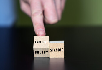 Wooden cubes form the German expressions 'selbststaendig' (self employed) and 'arbeitet staendig' (working permanently).