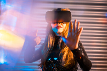 Woman in urban space wearing VR glasses at night