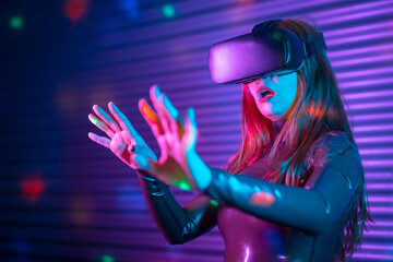 Surprised girl using virtual reality goggles at night
