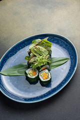 Japanese cuisine. Vegan rolls with avocado, herbs and carrots.