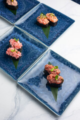 Japanese cuisine. Gunkan on blue plates
