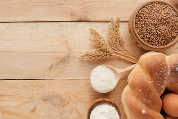 Ears of wheat, bag of grain on a wooden background. Round whole grain bread,  flour - ingredients...
