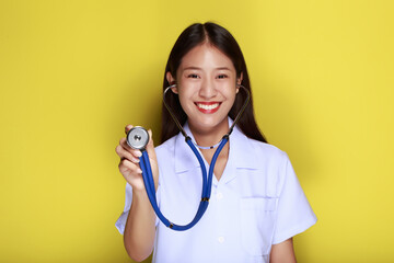 Portrait of a beautiful young woman in a yellow background,  Asian woman wearing a doctor's uniform...