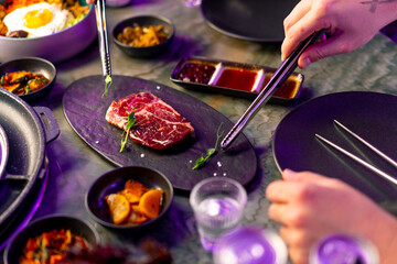 close-up top view delicious appetizing juicy piece of raw meat on table with sauces on appetizers...