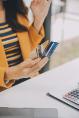 Women holding credit card and using smartphones at home.Online shopping, internet banking, store...