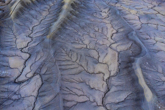 Intricate patterns of blue sand created by tidal forces