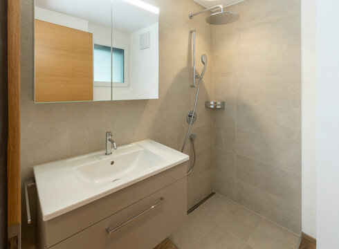Modern bathroom interior with beige tiles and sleek fixtures