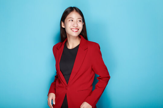 Portrait of a friendly young woman smiling happily, Portrait of a beautiful young woman in a light blue background, happy and smile, posting in stand position.