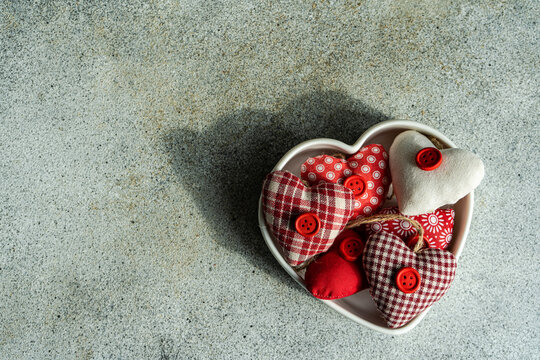 Handmade hearts in ceramic bowl on concrete background