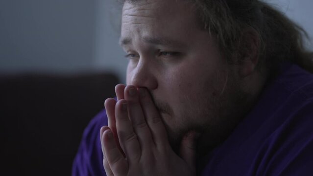 One anxious pensive man thinking about problems. Sad man sitting in dark room. Depression and anxiety disorder concept