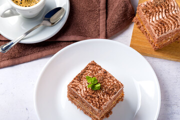 Chocolate cake cut into square pieces with nut cream