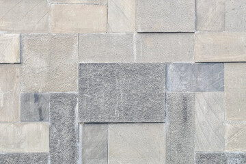 Wall made of gray tiles. The tiles are arranged in a geometric pattern, creating a visually...