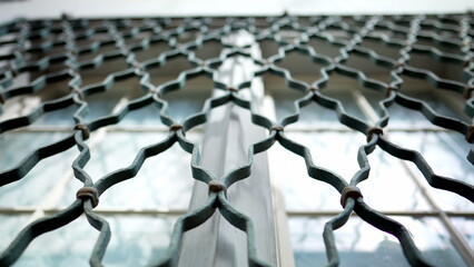 Metal window fence protection patterns demarcating property separation in building facade